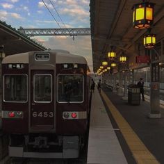 a train is pulling into the station at dusk