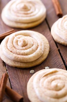 cinnamon roll cookies on a wooden table with cinnamon sticks and spices around the top cookie