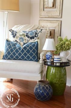 a living room filled with lots of furniture and decor on top of a hard wood floor