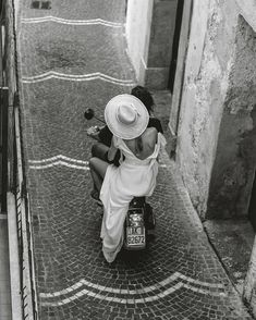 a woman sitting on top of a scooter next to a building and stairs