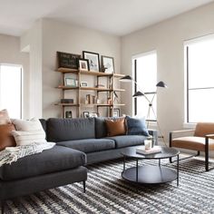 a living room filled with furniture and bookshelves next to two couches on top of a rug