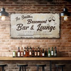 the bar and lounge sign is hanging on the brick wall behind the bar stools