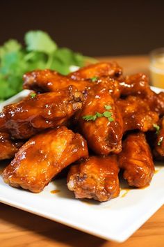 a white plate topped with chicken wings next to lettuce