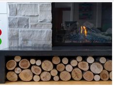 a fire place with logs stacked in front of it