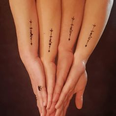 two girls with matching tattoos on their hands are holding each other's hands together