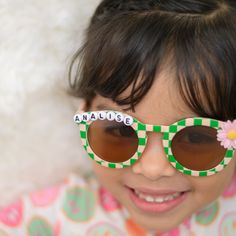 **SHIPS IN 1-2 BUSINESS DAYS** Listing is for one pair of sunglasses with personalization, and flower charm. Made to order.  Total width of flower shape on sunglasses is 5.11 inches. Frame width and height are 5.31 inches.  Toddler/ Kids sunglasses. Suitable for ages 3-8 Light to wear. Made of AC and PC material. UV 400 If you want a different color flower added, message me :) Playful Customizable Adjustable Sunglasses, Playful Polarized Sunglasses For Birthday, Trendy Personalized Sunglasses For Birthday, Trendy Customizable Sunglasses For Birthday, Playful Sunglasses With Tinted Lenses, Playful Tinted Sunglasses For Birthday, Playful Green Sunglasses For Beach, Fun Sunglasses With Tinted Lenses For Birthday, Fun Sunglasses With Uv Protection For Birthday