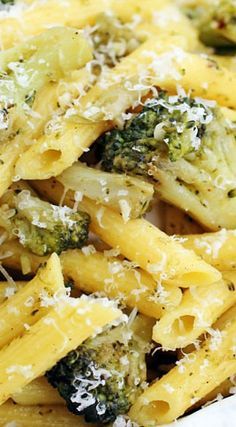 pasta with broccoli and parmesan cheese in a white dish on a table