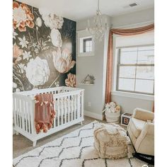 a baby's room with a floral wallpaper and white crib