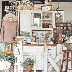 a room filled with lots of white furniture and decor on top of hard wood flooring