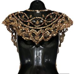 a black mannequin with gold and red beads on it's neckline