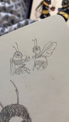 a drawing of two bees on top of a piece of paper next to each other