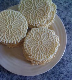 four cookies on a plate with white frosting