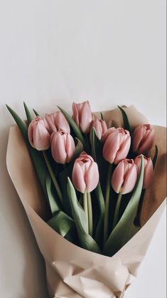 a bouquet of pink tulips wrapped in paper