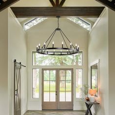 a large foyer with a chandelier and two doors leading to the front door