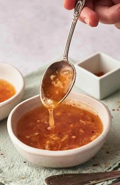 a spoon full of soup being poured into a bowl