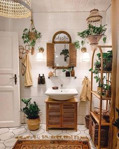 a bathroom with a sink, mirror and plants on the wall next to rugs