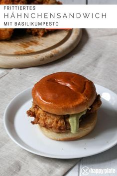 a fried chicken sandwich on a plate with ketchup