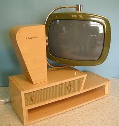 an old television sitting on top of a wooden stand