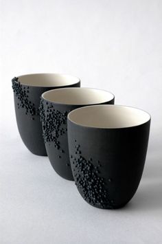 three black and white cups sitting next to each other