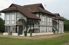 an old white building with a brown roof