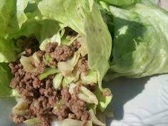 lettuce with ground meat and onions on a white plate, ready to be eaten