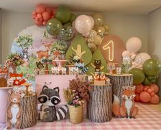 a table topped with lots of balloons and stuffed animals next to wooden stumps on top of a checkered floor