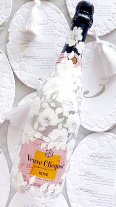 a bottle of wine sitting on top of white plates with paper doily around it