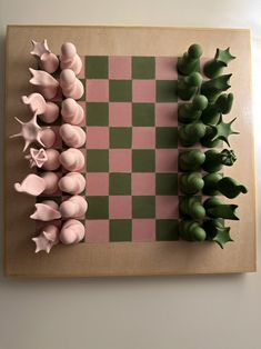 a checkerboard board with pink and green chess pieces