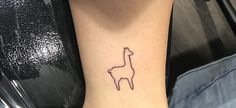 a small giraffe tattoo on the ankle that is black and white with a single line