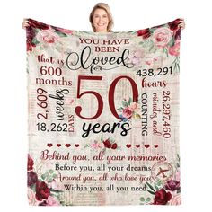 a woman is holding up a blanket with the words 50 years and roses on it