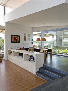 a large open living room with stairs leading up to the second floor and dining area