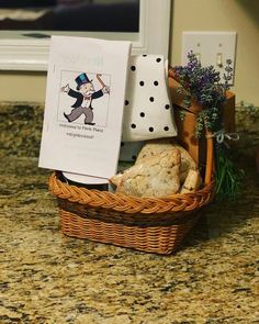 a basket filled with bread and cookies on top of a counter next to a sign