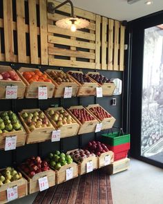 an open air market with lots of fruits and vegetables on display next to a glass door