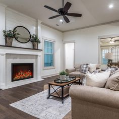 a living room filled with furniture and a fire place in the middle of it's wall