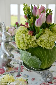 a vase filled with lots of flowers on top of a table