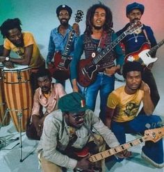 a group of people that are posing for a photo with some guitars and drums in front of them