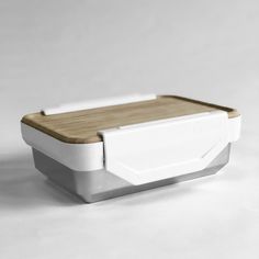 a white and wood lunch box on a table