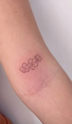 a small flower tattoo on the arm