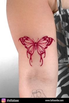 a woman's arm with a red butterfly tattoo on the left side of her arm