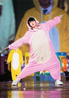 a man in a pink outfit is dancing on stage