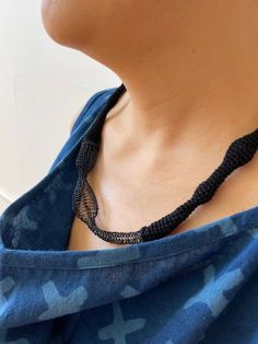 Black knitted necklace made with organic cotton and metal. This jewelry necklace collection is made in collaboration with Karine Nicon, fiber artist based in Douarnenez, France. She does fine knitted arts and jewelry. Here, she mixed for this collection cotton and metal that she knitted together. Due to the hand made process, every piece is slightly different from the next one. Embrace the slight variations knowing your product is truly unique and special. Material : organic cotton & metal Dimen Handwoven Black Jewelry For The Beach, Artisan Black Necklace For Beach, Black Handwoven Jewelry Bracelet, Traditional Black Handwoven Necklace, Adjustable Handwoven Black Necklace, Adjustable Black Handwoven Necklace, Knitted Necklace, Wave Necklace, Sustainable Textiles