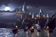 the hogwarts castle is lit up at night with people in boats on the water