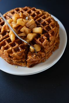 two waffles on a plate with syrup being drizzled over them