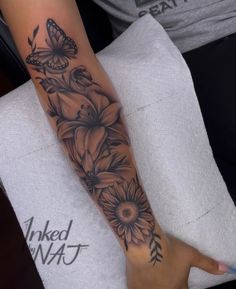 a woman's arm with flowers and butterflies on it