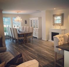 a living room filled with furniture and a fire place next to a dining room table