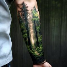 a man's arm with a forest scene on it