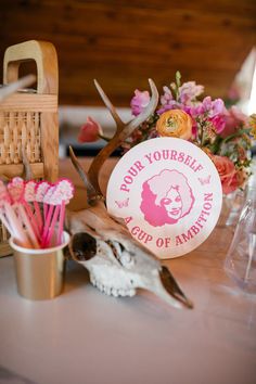 a table topped with lots of pink flowers and antlers next to a wooden basket