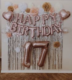 a birthday backdrop with balloons and streamers in the shape of an number seven on it