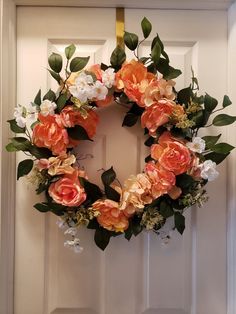 an orange and white wreath hanging on the front door