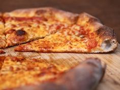 two slices of pizza sitting on top of a wooden cutting board